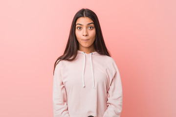 Obraz premium Young pretty arab woman wearing a casual sport look shrugs shoulders and open eyes confused.