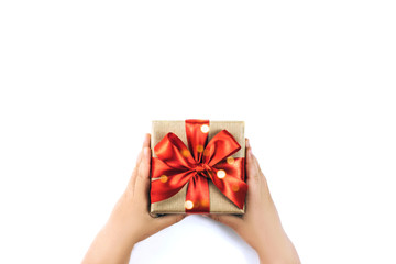 Child's hands holding gift box isolated on white background.