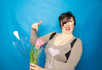 disgruntled woman with a bouquet of flowers emotionally shows hatred and disgust for cut flowers....