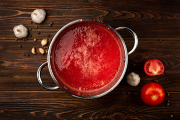 Tomato juice on dark wooden background.