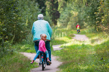active senior with grandkids riding bikes in nature