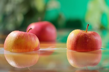 Juicy red apples in water. Apples fall into the water, drops. Useful food snacks.