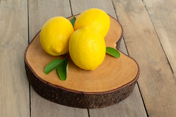 fresh lemons with green leaves isolated on wood background