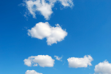 Obraz premium Few funny sheep shaped clouds in blue sky