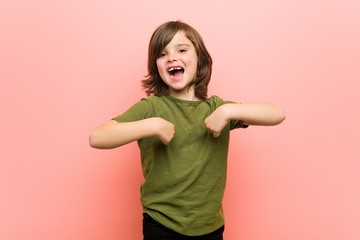 Little boy surprised pointing with finger, smiling broadly.