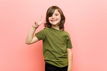 Little boy joyful and carefree showing a peace symbol with fingers.