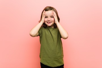 Little boy laughs joyfully keeping hands on head. Happiness concept.