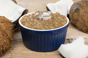 Brazilian dessert made of tapioca pearls called sagu in coffee flavor with coconut in wood background