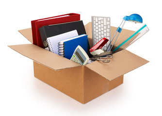 Cardboard moving box filled with office supplies, isolated on white background. Contains clipping path.