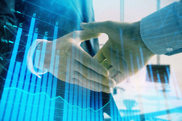 Multi exposure of financial graph on office background with two businessmen handshake. Concept of success in business