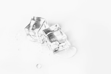 ice cube and glass of water on white background