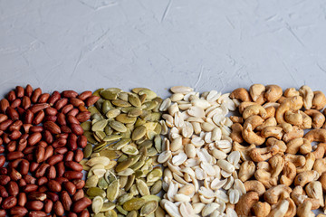Food for vegetarians and more.  Nuts, seeds are very useful and rich in essential trace elements.  Cashews, peanuts, pumpkin seeds are nutritious and delicious.  Copy space.  Grey background.