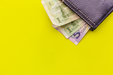 Black leather Men's Wallet with chinese yuan cash on yellow background. Place for text