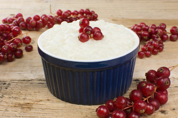 Brazilian dessert made of tapioca pearls called sagu in cream flavor with redcurrant in wood background