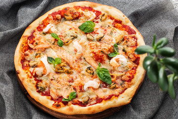 Seafood Italian pizza with shrimp,squid, mussels, fresh herbs and mozzarella on a crusty base viewed from above on Gray background. Horizontal photo.