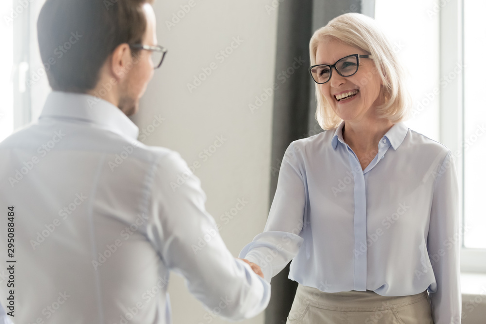 Canvas Prints Cheerful middle aged businesswoman handshaking greeting new employee