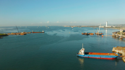 City of Cebu top view, the port in the harbor and cargo ships and a highway with cars near the sea. Philippines, Cebu.