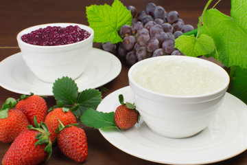Brazilian dessert made of tapioca pearls called sagu in  cream and red wine flavors with grapes and strawberries in wood background a