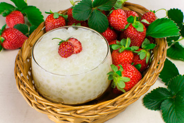 Brazilian dessert made of tapioca pearls called sagu in cream flavor in a basket with strawberries