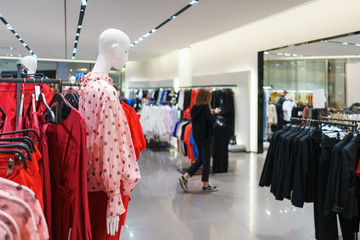 Fashionable clothes on hangers in a store.