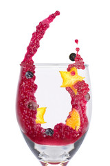 Splash of Brazilian dessert made of tapioca pearls called sagu in red wine flavor with fruits in a glass