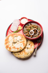 Pindi Chole Kulche or roadside choley Kulcha popular in India and pakistan is a popular streetfood. It's a spicy Chickpea or chana curry served with Indian Flat Bread. selective focus