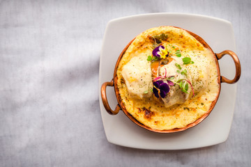 Succulent homemade chili pepper and cheese souffle stuffed served au gratin with creamy cheese. Peruvian food. White background. Top view