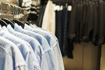 Fototapeta premium Fashionable clothes on hangers in a store.