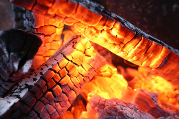 Close-up of burning log in bonfire. Large orange flame from fire with woods. Light and ash from...