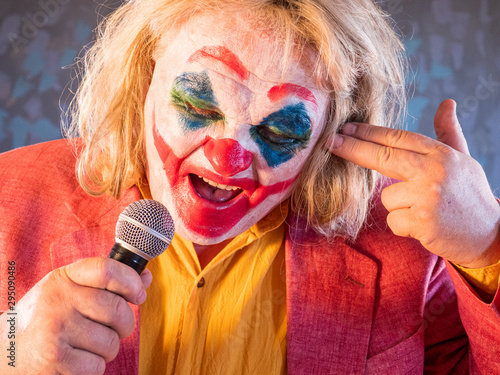 Portrait Male Clown In Pink Dressed For Halloween Actor Made Makeup Of  Crazy, Evil Clown Faced With Bloody Smile White Face Makeup Scary Laugh  Model In Halloween Costume With Microphone Adult Wall