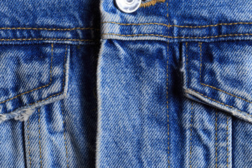 Dark blue jeans texture for design. Part of the cyan jeans jacket with pocket and a metallic button close-up. - Image