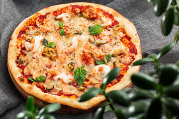 Seafood Italian pizza with shrimp,squid, mussels, fresh herbs and mozzarella on a crusty base viewed from above on Gray background. Horizontal photo.