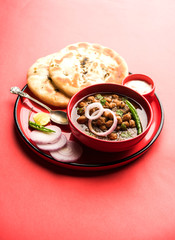 Pindi Chole Kulche or roadside choley Kulcha popular in India and pakistan is a popular streetfood. It's a spicy Chickpea or chana curry served with Indian Flat Bread. selective focus