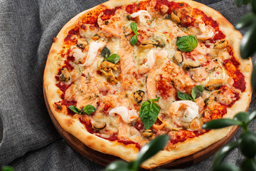 Seafood Italian pizza with shrimp,squid, mussels, fresh herbs and mozzarella on a crusty base viewed from above on Gray background. Horizontal photo.