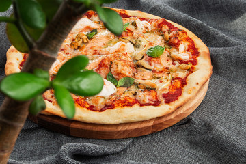 Seafood Italian pizza with shrimp,squid, mussels, fresh herbs and mozzarella on a crusty base viewed from above on Gray background. Horizontal photo.