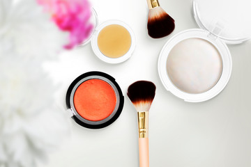 Cosmetic makeup powder and brushes on white background. Flat lay copy space. Mock-up concept composition, top view