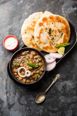 Pindi Chole Kulche or roadside choley Kulcha popular in India and pakistan is a popular streetfood. It's a spicy Chickpea or chana curry served with Indian Flat Bread. selective focus