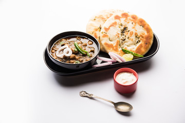 Pindi Chole Kulche or roadside choley Kulcha popular in India and pakistan is a popular streetfood. It's a spicy Chickpea or chana curry served with Indian Flat Bread. selective focus