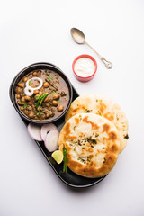 Pindi Chole Kulche or roadside choley Kulcha popular in India and pakistan is a popular streetfood. It's a spicy Chickpea or chana curry served with Indian Flat Bread. selective focus