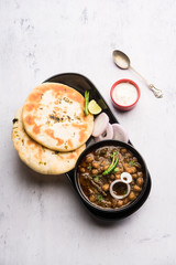 Pindi Chole Kulche or roadside choley Kulcha popular in India and pakistan is a popular streetfood. It's a spicy Chickpea or chana curry served with Indian Flat Bread. selective focus