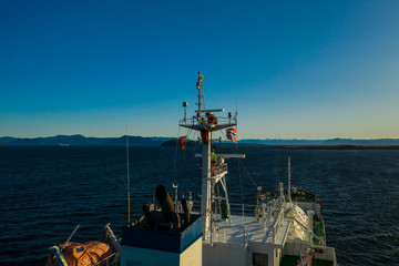 Ship on anchorage and seaman working on the mast
