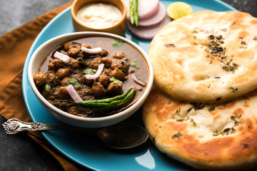 Pindi Chole Kulche or roadside choley Kulcha popular in India and pakistan is a popular streetfood. It's a spicy Chickpea or chana curry served with Indian Flat Bread. selective focus