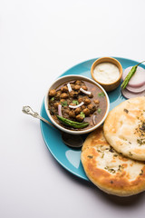 Pindi Chole Kulche or roadside choley Kulcha popular in India and pakistan is a popular streetfood. It's a spicy Chickpea or chana curry served with Indian Flat Bread. selective focus