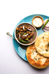 Pindi Chole Kulche or roadside choley Kulcha popular in India and pakistan is a popular streetfood. It's a spicy Chickpea or chana curry served with Indian Flat Bread. selective focus