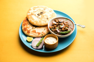 Pindi Chole Kulche or roadside choley Kulcha popular in India and pakistan is a popular streetfood. It's a spicy Chickpea or chana curry served with Indian Flat Bread. selective focus