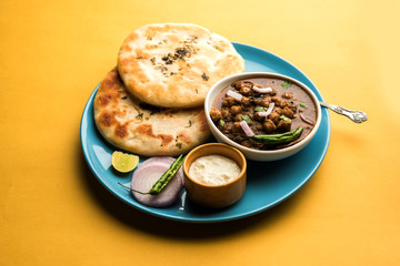 Pindi Chole Kulche or roadside choley Kulcha popular in India and pakistan is a popular streetfood. It's a spicy Chickpea or chana curry served with Indian Flat Bread. selective focus