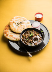 Pindi Chole Kulche or roadside choley Kulcha popular in India and pakistan is a popular streetfood. It's a spicy Chickpea or chana curry served with Indian Flat Bread. selective focus