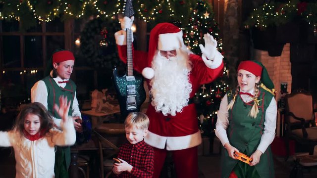 Santa Claus has fun, sings and dances with his children and elves in his New Year's residence