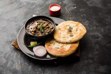 Pindi Chole Kulche or roadside choley Kulcha popular in India and pakistan is a popular streetfood. It's a spicy Chickpea or chana curry served with Indian Flat Bread. selective focus
