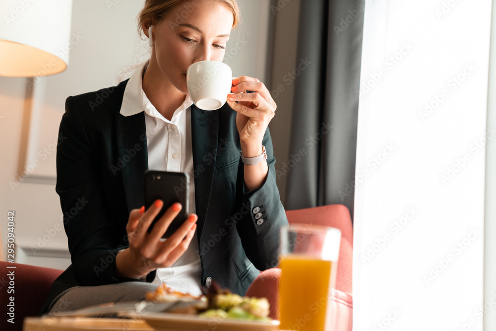 Wall mural blonde business woman sit indoors have a dinner.